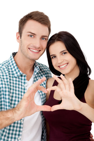 Playful couple fooling on valentine day. Beautiful young lovers are joining and smiling, making heart frame from their hands isolated on white backgroundの写真素材