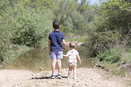 Children watching the riverの写真素材