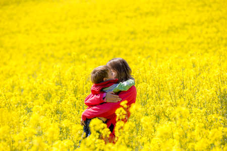 Mother and son walking through the rapeseed field.の写真素材