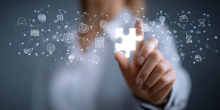 Businesswoman on blurred background connecting 3D rendering puzzle pieces with iconsの素材