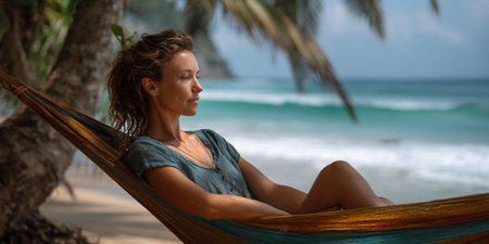 Young woman relaxing in hammock on tropical beach. Vacation conceptの素材