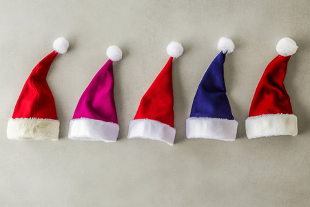 Santa Claus hats on gray background. Christmas and New Year concept.の素材
