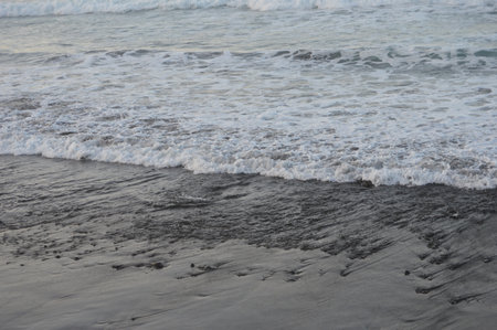 Beautiful sea wave on the black sand beach in the morning.の写真素材