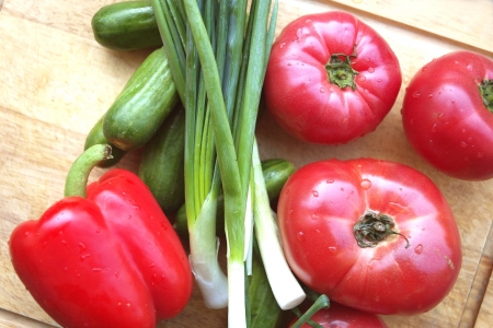 Tomatos and cucumbers on a wooden tray close outdoor shotの写真素材