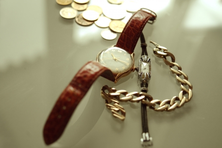 a pair of antique watch, coins and golden braceletの写真素材