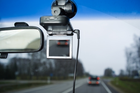 rear view mirror with portable car camcorder, gprs navigator on windscreen, shot from passenger front seatの写真素材