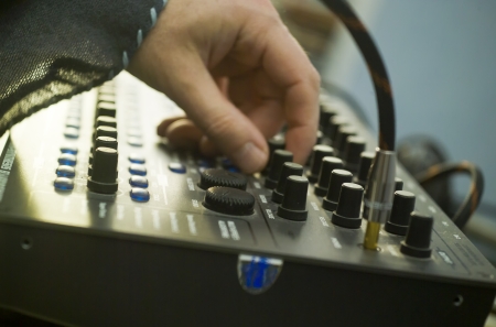 Close up shot of DJ s hand creating music, shallow depth of field, focused on nearest knobの写真素材