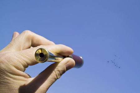 hand holding a spyglass, somebody looking through it at the flock of birds or military jetsの写真素材