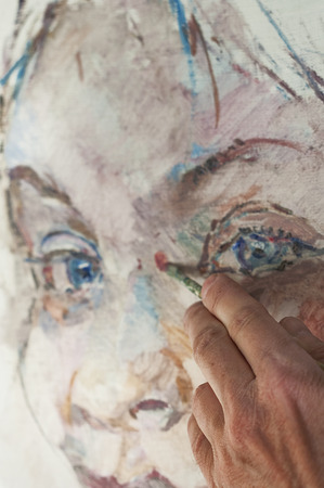 Hand of artist at work, painting a female portrait, close up shot with particular focusの写真素材
