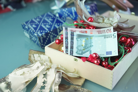 Christmas gifts and toys with euro banknotes in a center of composition, shot with selective focusの写真素材