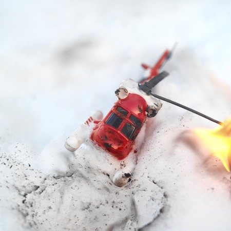 Toy helicopter crashed in snow, outdoor close up shot with shallow DOF, imitation of real accidentの写真素材