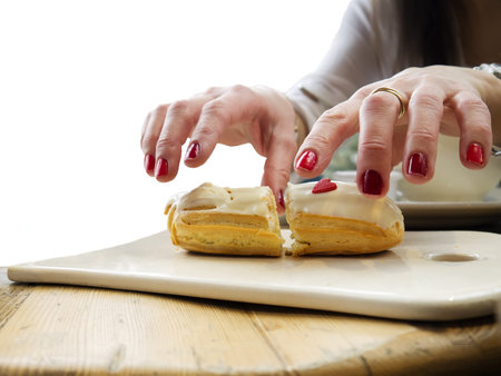 Female hands over a plate with cake, isolated on white shot with particular focus