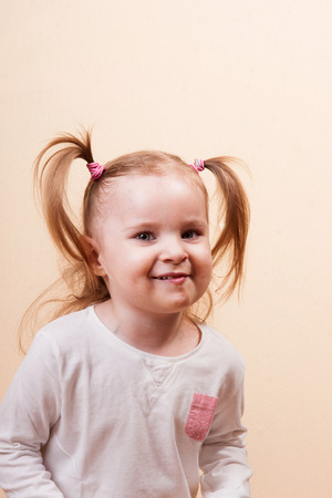 Portrait of a cute little tricky girl, studio vertical shotの写真素材