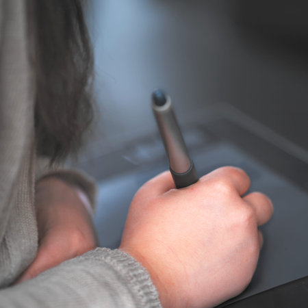 Close up of a little girl hand writing or drawing on computer, selective focus shot with shallow DOFの写真素材