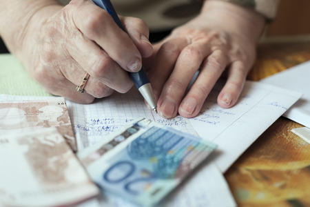 Female hands filling a form, front shot with a shallow DOFの写真素材