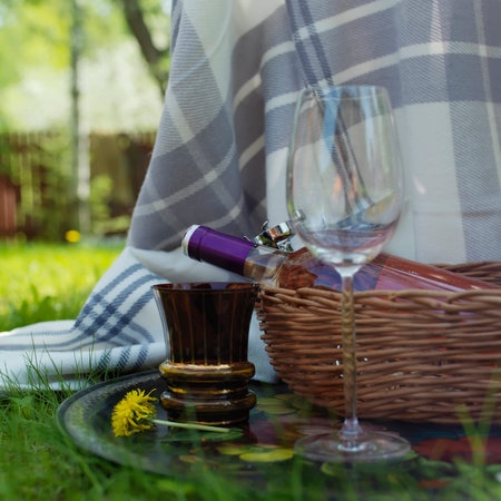 Two wine glasses and bottle of red wine in a basket, outdoor square shotの写真素材