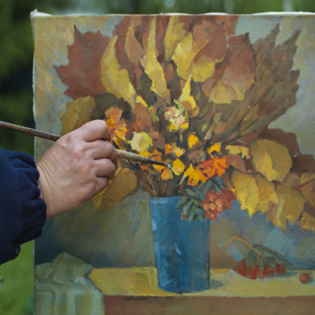 Human hand painting autumn still life, outdoor square shotの写真素材