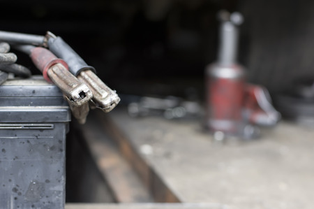 Car jump leads and car jack in the blurred background, outdoor shot with shallow depth of fieldの写真素材