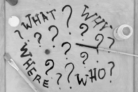 Hand written words and question marks with abandoned paintbrushes, concept of uncertainty in black and whiteの写真素材