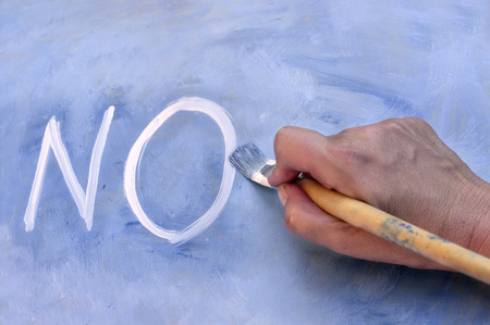 Female hand writing word NO by paintbrush, concept of prohibitionの写真素材