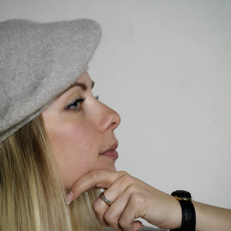 Young woman with long blond hair with a thoughtful distant gaze, studio squre shotの写真素材