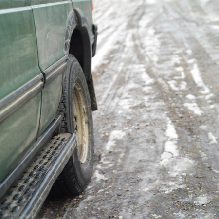 Cropped shot of a dirty car on a slippery icey road, outdoor shot with selective focus