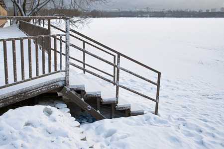 Frozen lake in the foreground and urban landscape in the blurred backgroundの写真素材