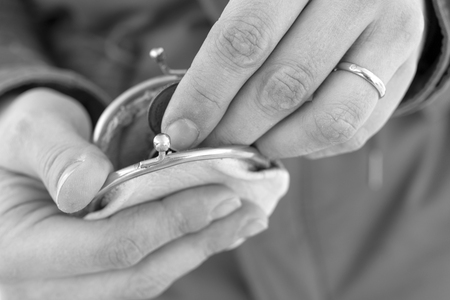 Female hands counting money in a retro looking wallet, concept of poverty, in black and whiteの写真素材