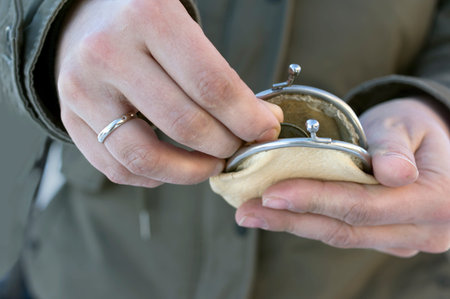 Female hands counting coins in a retro looking wallet, concept of poverty, shallow depth of field