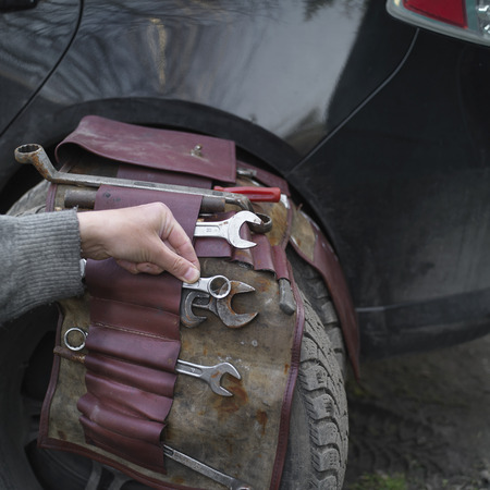 Hand of the mechanic fixing a broken car while travel;の写真素材