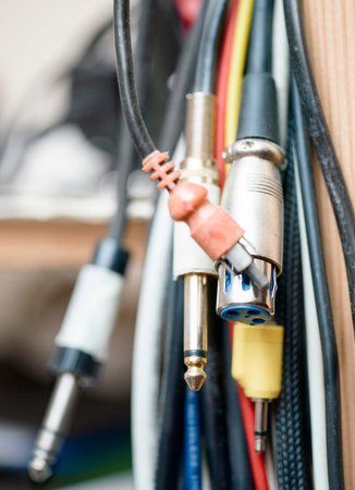 Bunch of audio plugs, connectors and cables, shallow depth of field vertical macro shot
