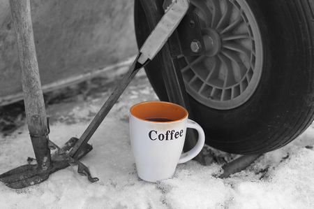 Cup of fresh made coffee next to work tools and garden trolley. Outdoor selective color shotの写真素材