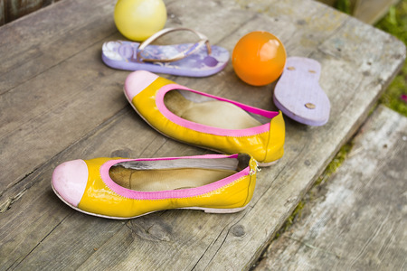 Children shoes, sandals and colorful balls left on the wooden stairs, concept of summertime fun, selective focusの写真素材