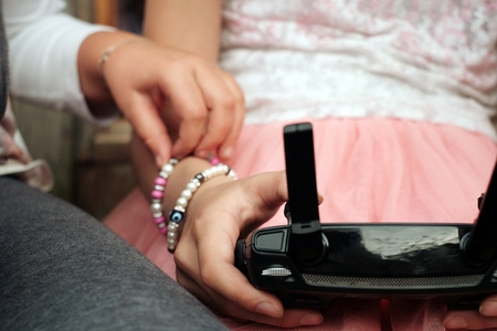 Children playing while holding a remote control in hands, closeup cropped photoの写真素材