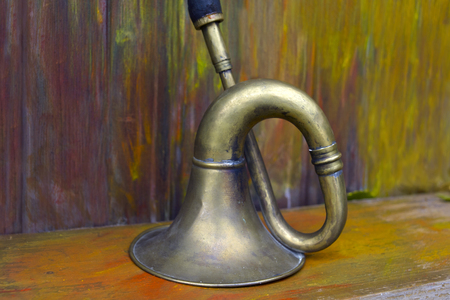 Old brass musical instrument placed on the painted shelf or wooden table, closeup shotの写真素材