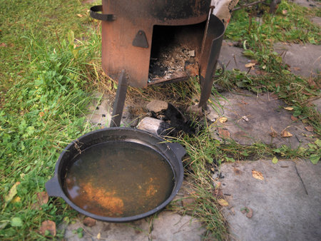 Abandoned rusty garden stove and frying pan, outdoor photoの写真素材