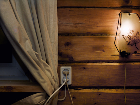 Wall light on the wooden wall next to the curtain and window, interior cropped shotの写真素材