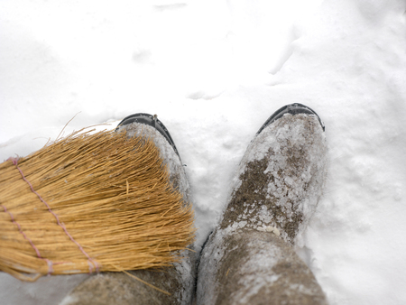 Cleaning the snow boots with broom, outdoor above viewの写真素材