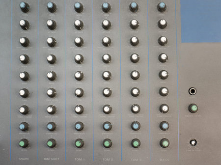 Face of a retro drum machine or synthesizer with rotary knobs for control