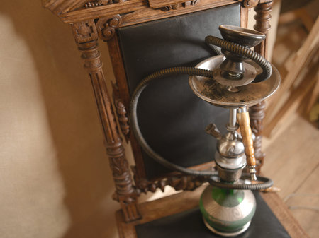 Hookah pipe placed on a vintage wooden chair, high angle vertical shot