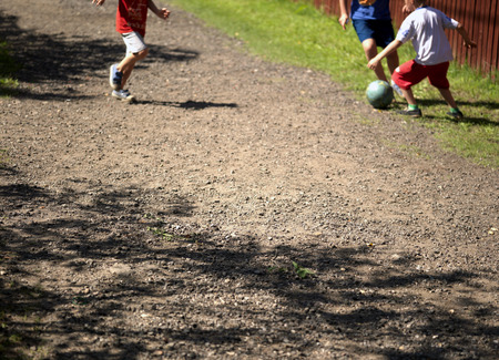 Children playing football on the street, blurred motion selective focus shotの写真素材