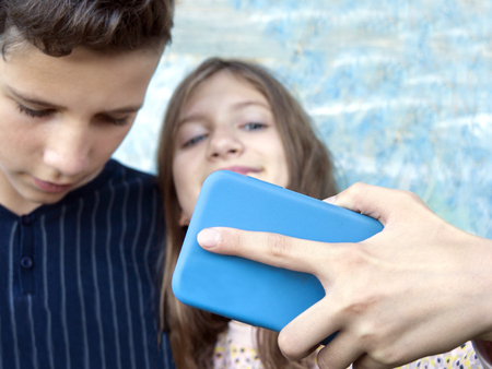Teenagers taking selfie on mobile phone, selective focus portraitの写真素材