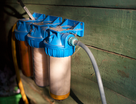 Bunch of home water filters mounted on a wooden wall, indoor closeupの写真素材
