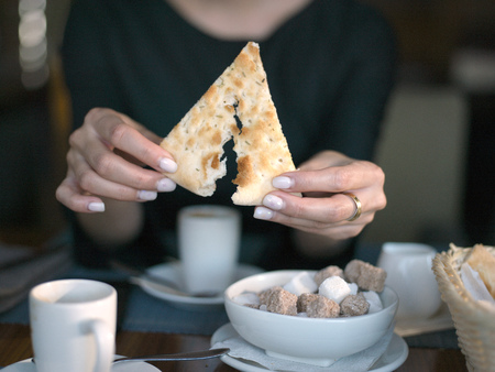 Female hands splitting a crisp in two pieces, indoor closeupの写真素材