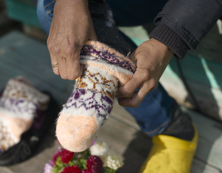 A woman putting wool socks on her feet, outdoor cropped shotの写真素材