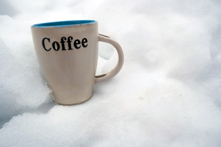 Cup of fresh hot coffee placed on the snow to cool down, outdoor closeupの写真素材