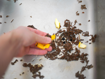 Selective focus of a hand unclugging a kitchen sink drainの写真素材