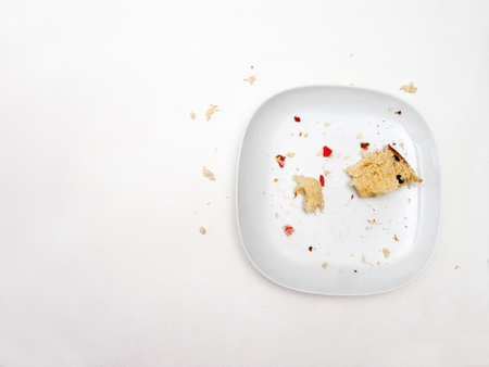 Eaten biscuit crumples on ceramic plate  placed on a table, overhead shotの写真素材