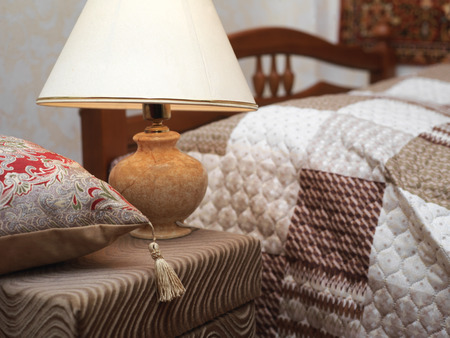 A bedroom interior with a lamp and pillow in the foreground