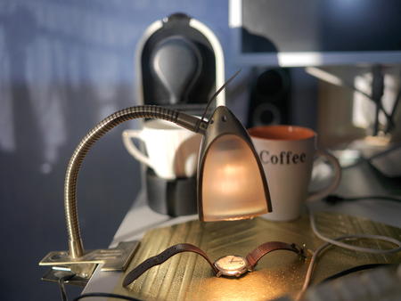 Wrist watch and coffee cup on a messy kitchen table, indoor close-upの写真素材
